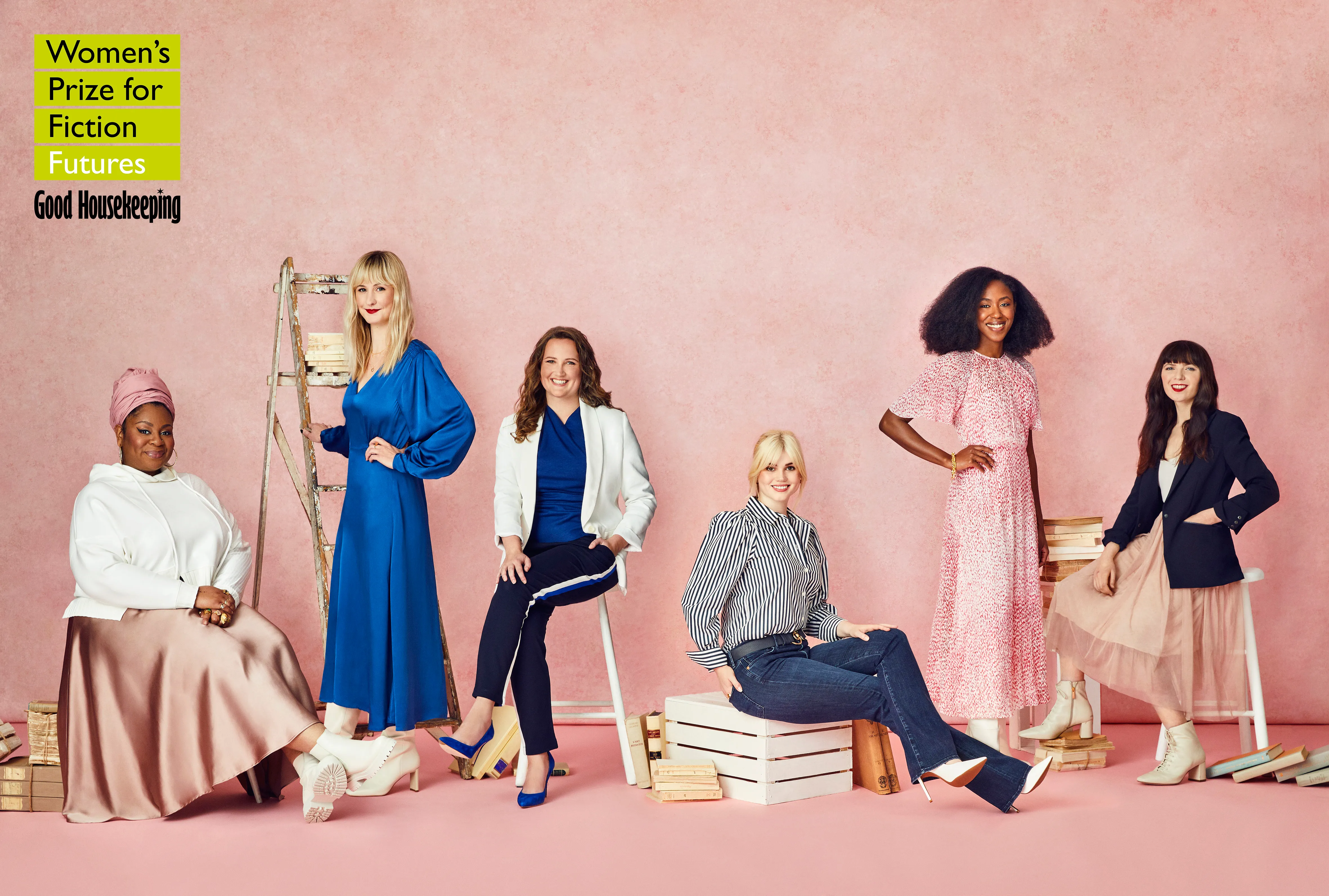 Six women stand in front of a pink backdrop