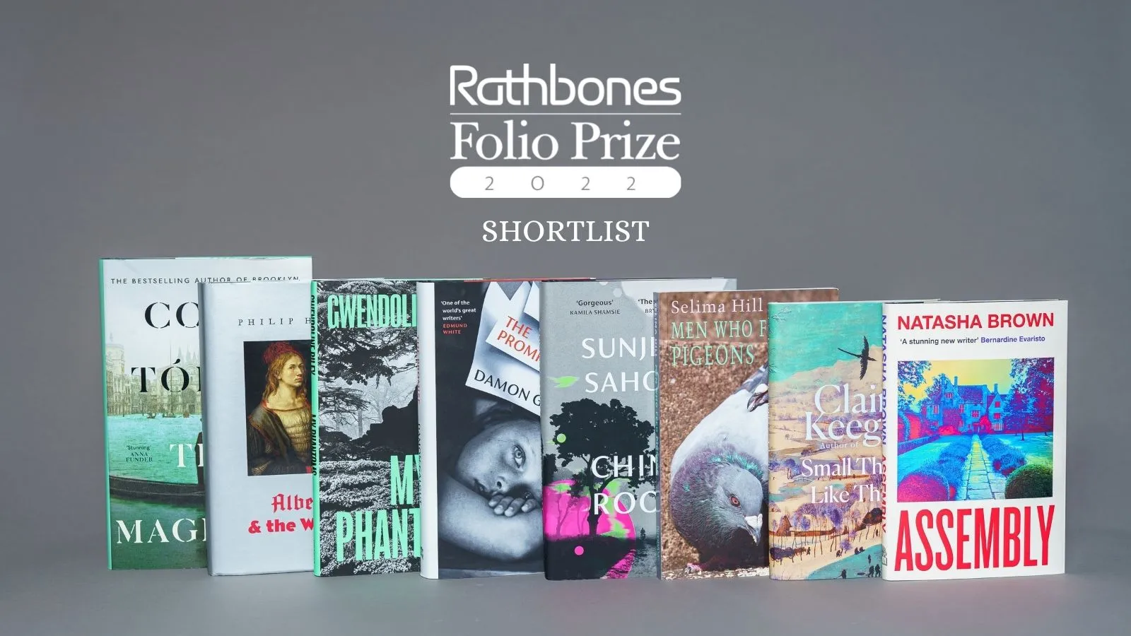 A photograph of eight books placed in an overlapping line against a grey background. Text above the books reads: Rathbones Folio Prize 2022 Shortlist